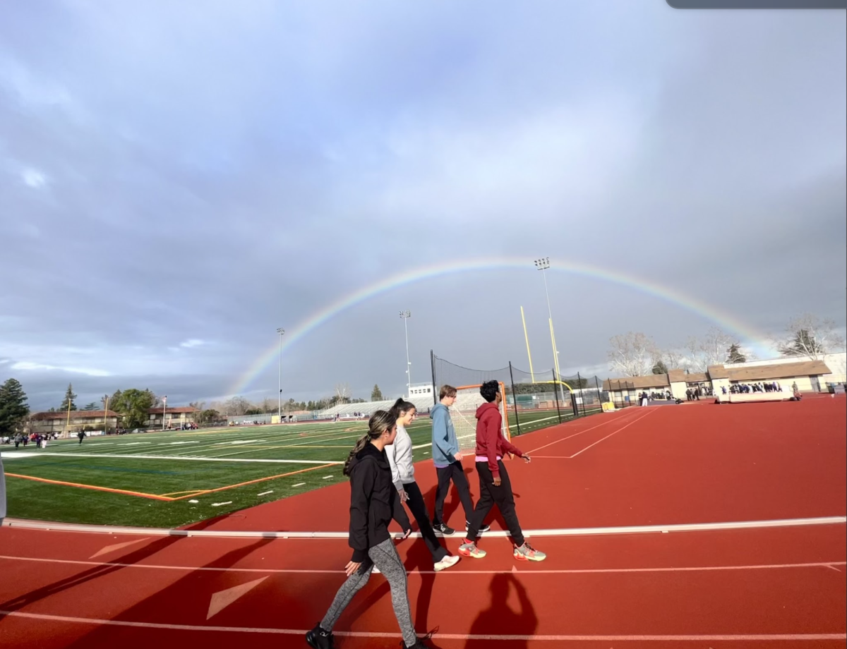 Track+and+field+athletes+take+warmup+laps+during+a+cloudy+spring+day.